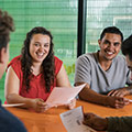 Two students laughing with friends