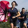 Sports students running with parachutes