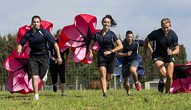 Sports students running with parachutes