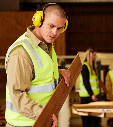 Student moving timber to be cut