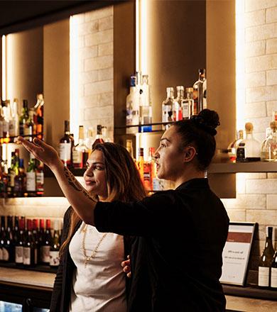 Student being taught by manager behind the bar
