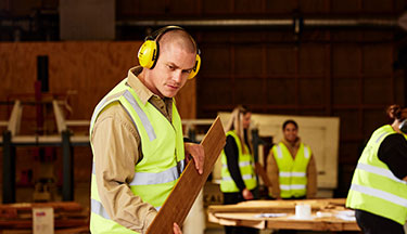 Student moving timber to be cut