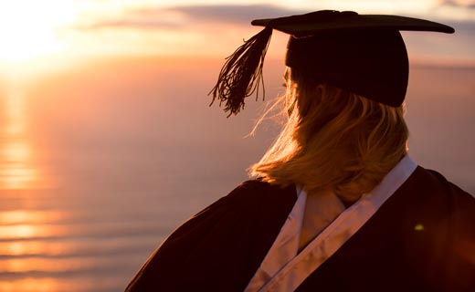 Graduate standing on top of Mount Maunganui