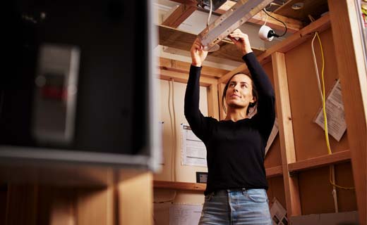 Student fixing a light fitting