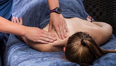 Massage student massaging client's shoulder