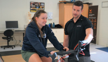 Dr Daniel Wilson with research subject on a bike