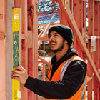 Carpentry student checking house frames are level