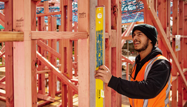 Carpentry student checking house frames are level