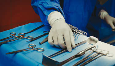 Surgeon picking up some scissors Surgeon picking up some scissors