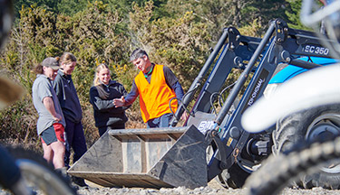 Heavy Automotive Engineering students surrounding a tractor with their tutor