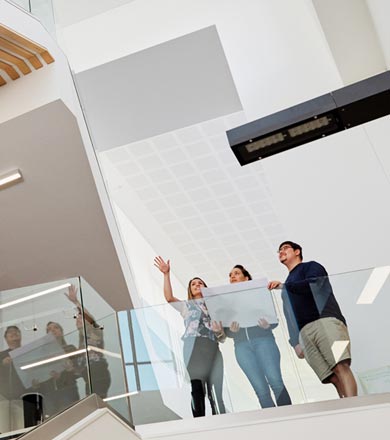 Architecture students with tutor looking over building drawings