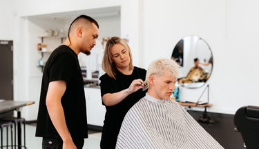 Toi Ohomai tutor demonstrating to student how to cut hair