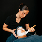 Beauty student applying a facial mask to client