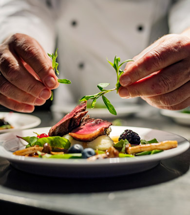 Culinary arts student garnishing a plate of food