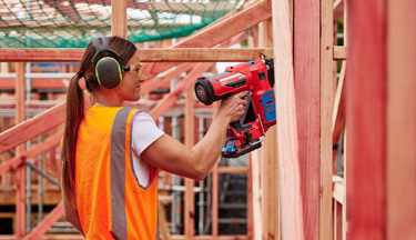 Carpentry students using a nail gun