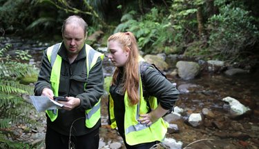 Conservation operation students looking over coordinates on a map