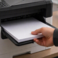 Person pulling out paper of a printer