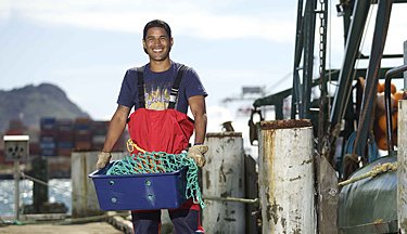 Maritime student carrying a container at the dock