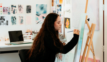 Creative student painting on a canvas