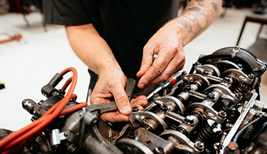 Automotive student working on a car engine