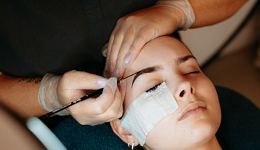 Beauty student working on a client's eyebrows