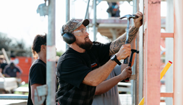 Carpentry tutor hammering in a nail