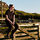 Farming student sitting on a fence