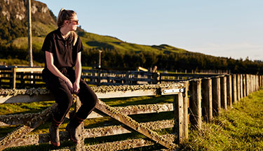Farming student sitting on a fence