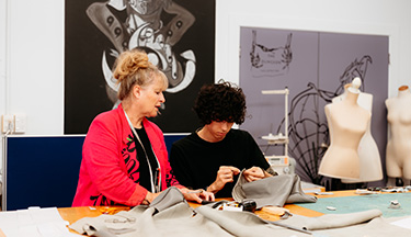 Fashion tutor overseeing their students work