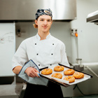 Baking student holding a tray of baking