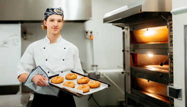 Baking student holding a tray of baking