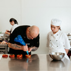 Baking tutor showing student how to pipe