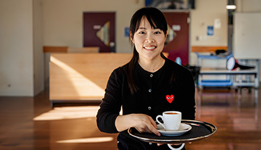 Barista student serving coffee