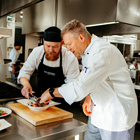 Culinary student with tutor plating up food