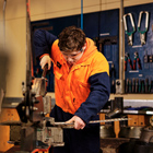 Engineering student using a guillotine to cut a sheet of metal