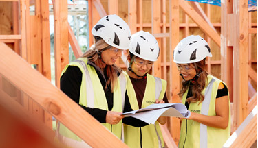 Health and Safety students with tutor looking over plans
