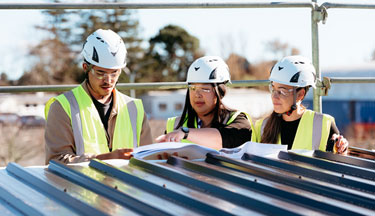 Health and Safety students with their tutor looking over plans