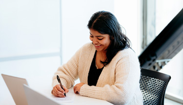 Business student writing down notes