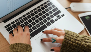 Management student typing on their laptop