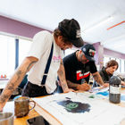 Creative student working on their art with their tutor