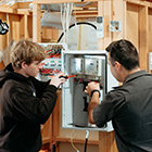 Electrical student with tutor going through some wiring 