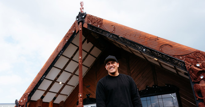 Toi Ohomai student standing outside Tangatarua Marae