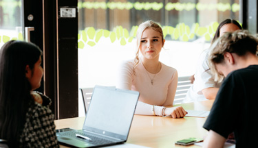 Postgraduate students sitting around a table