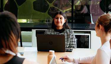 Postgraduate student studying with other students