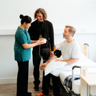 Healthcare Assistant with their tutor and patient