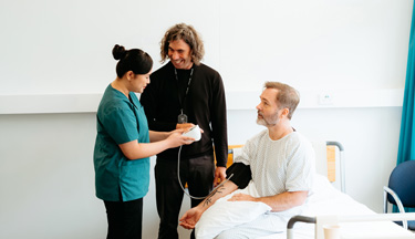 Healthcare Assistant with their tutor and patient