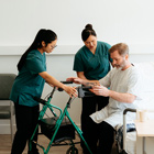 Healthcare Assistants helping a patient to stand