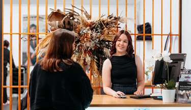 Student serving a customer in the salon
