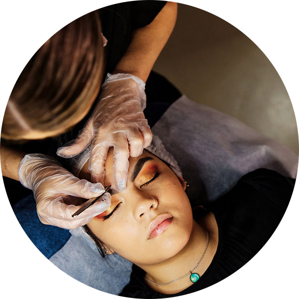 Beauty student plucking a clients eyebrows