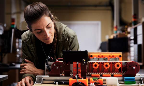 Engineering student inspecting components on a machine